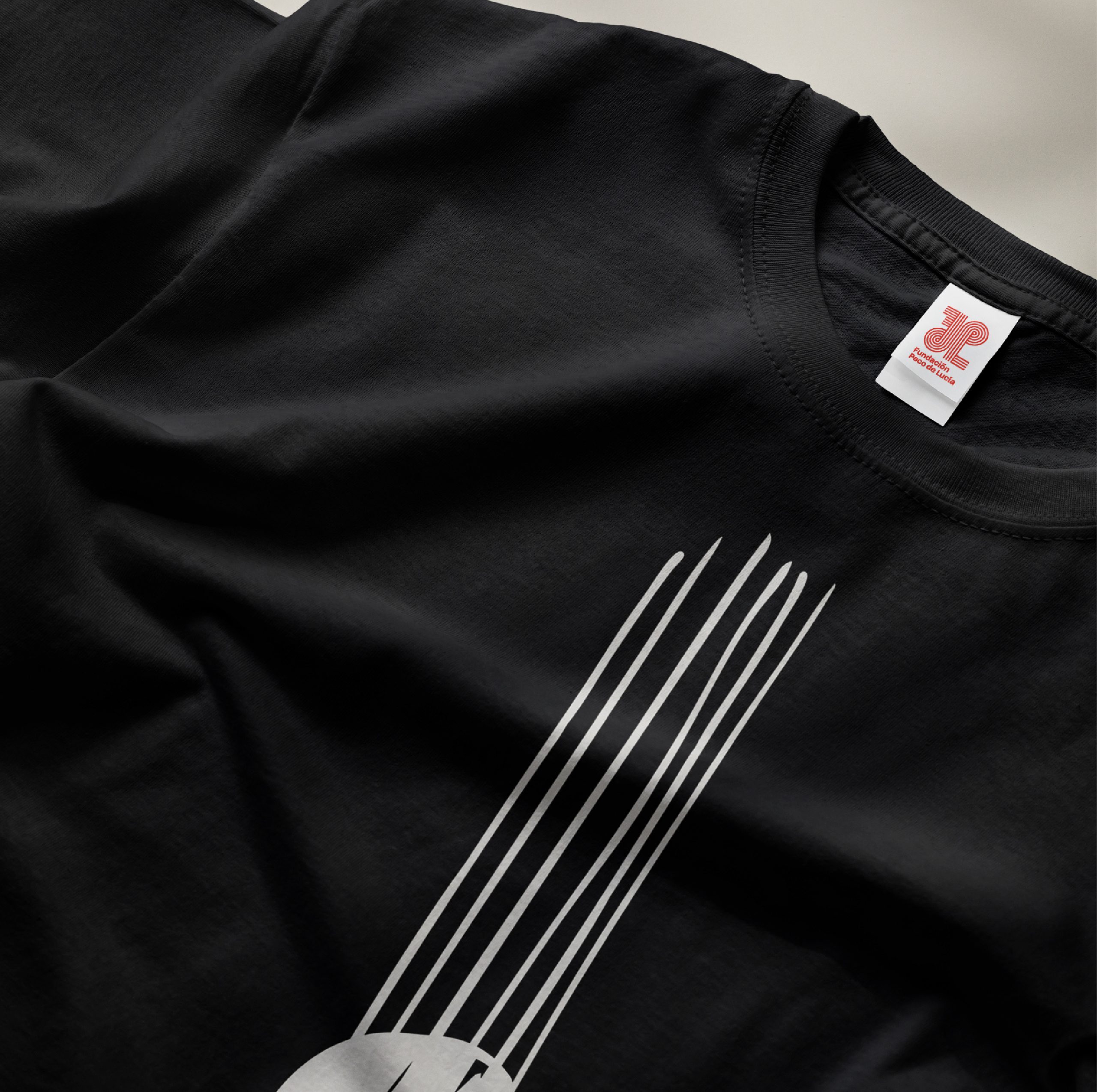 Detalle de camiseta negra de la colección Cuerdas inspirada en la guitarra flamenca de Paco de Lucía